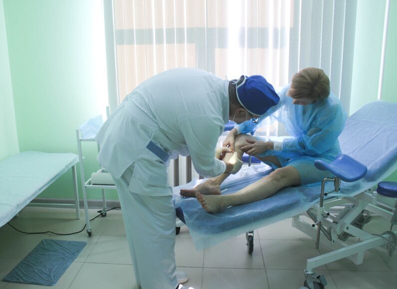 Um cirurgião examina as veias de um paciente antes de realizar uma operação.